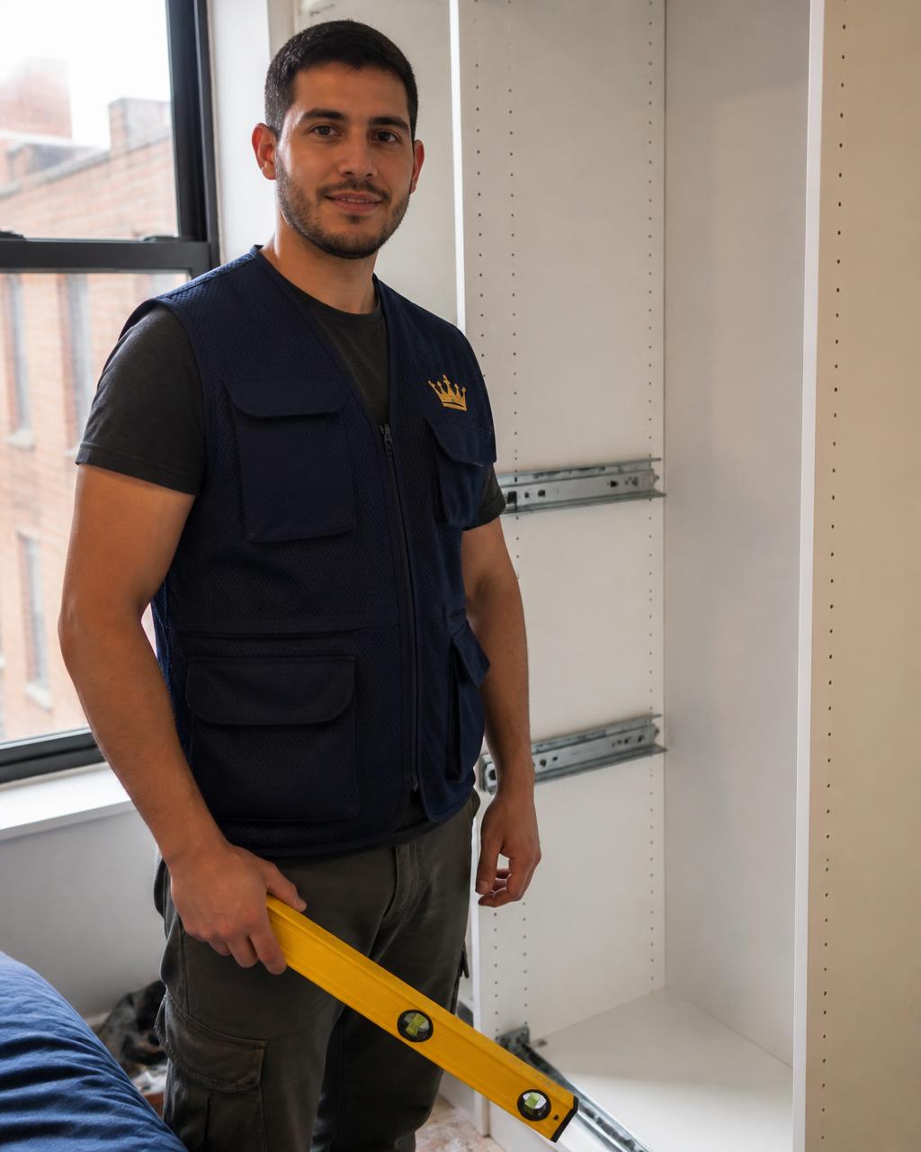 Simply King technician with a spirit level beside a wardrobe build in Queens